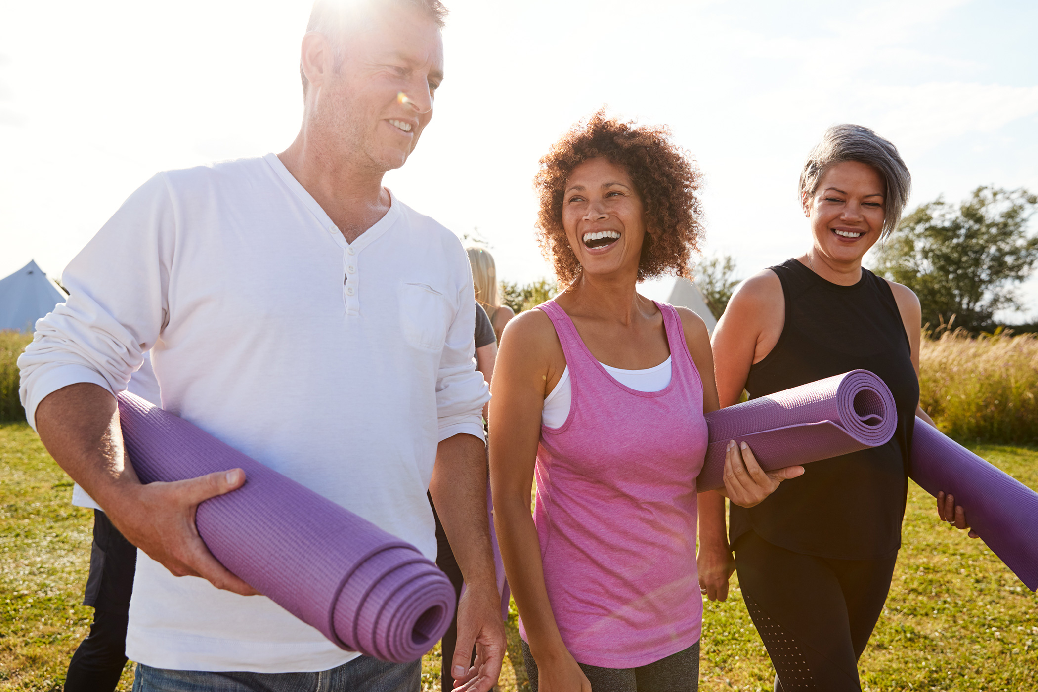 Men and women chatting after an outdoor yoga session
