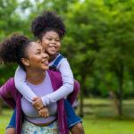 Mother and daughter, outside, playing and smiling