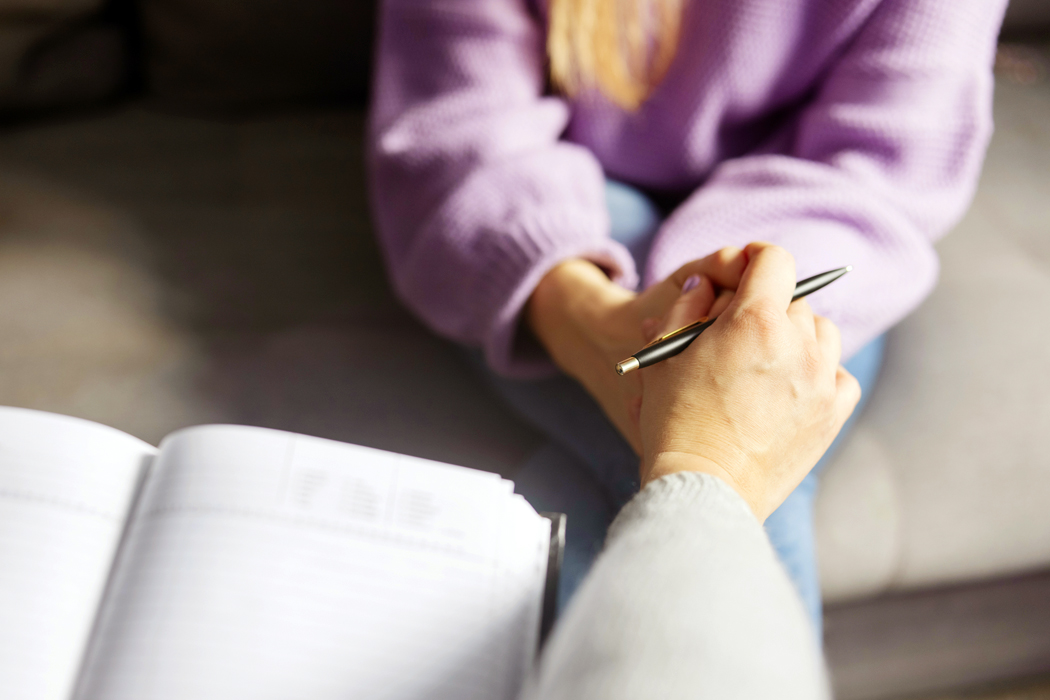 Woman holding hands with a mental health professional in an office setting