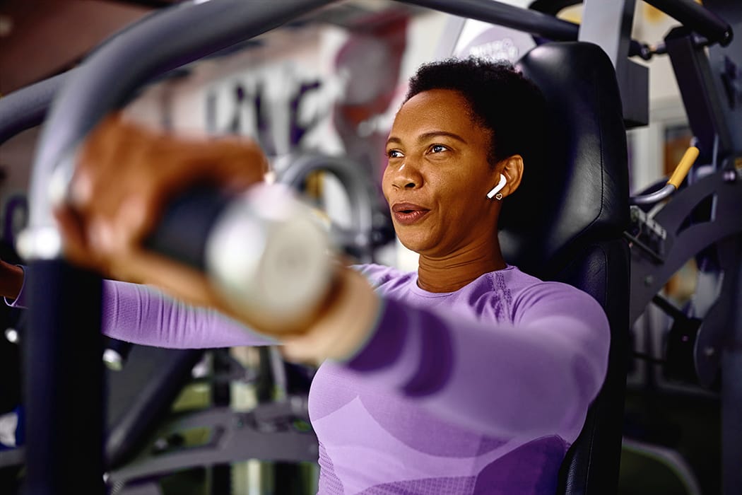 Woman lifting weights on a bench press machine