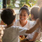 A happy smiling woman enjoying healthy snack with her children