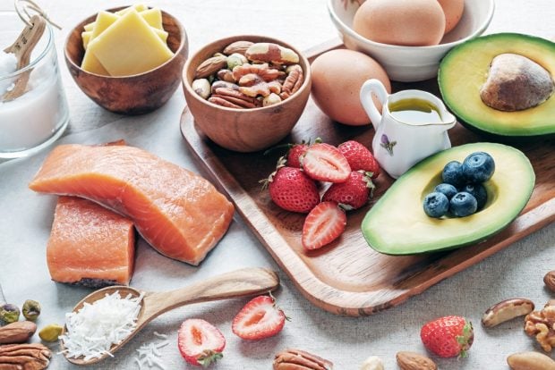 A spread of fresh fish, berries, nuts, cheese, and healthy fats