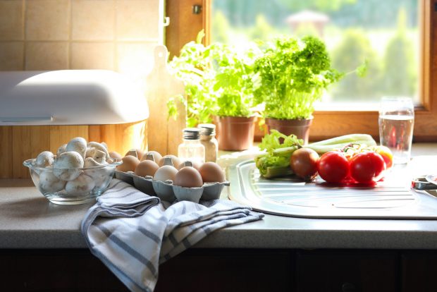 leafy greens, vegetables, and eggs in a warmly lit kitchen