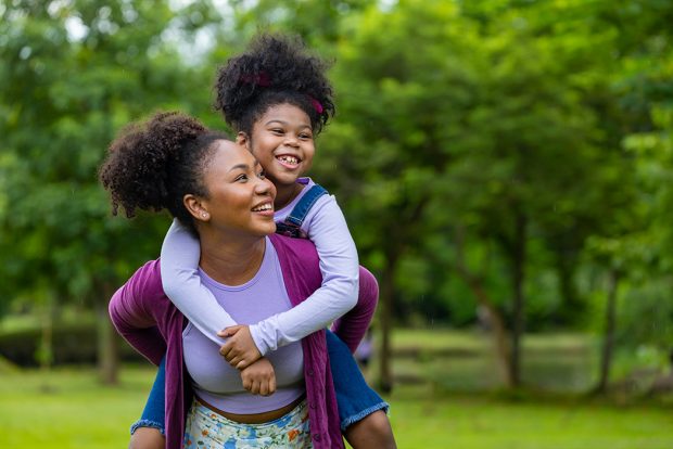 Mother and daughter, outside, playing and smiling