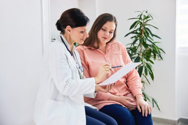 Woman reviewing a questionnaire with her doctor in a doctor's office setting