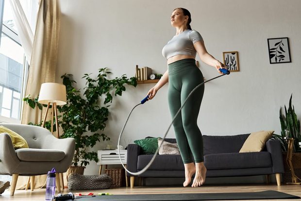 Healthy fit woman jumping rope in a home setting