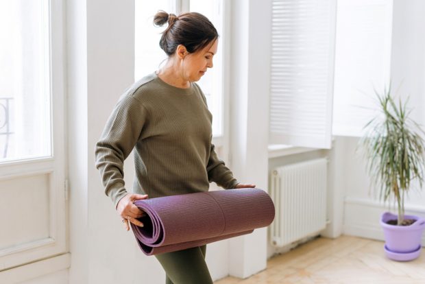 woman-rolling-yoga-mat-1050x700