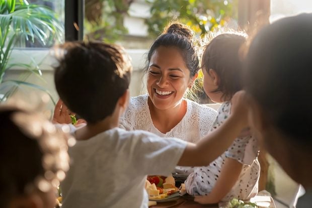 A happy smiling woman enjoying healthy snack with her children
